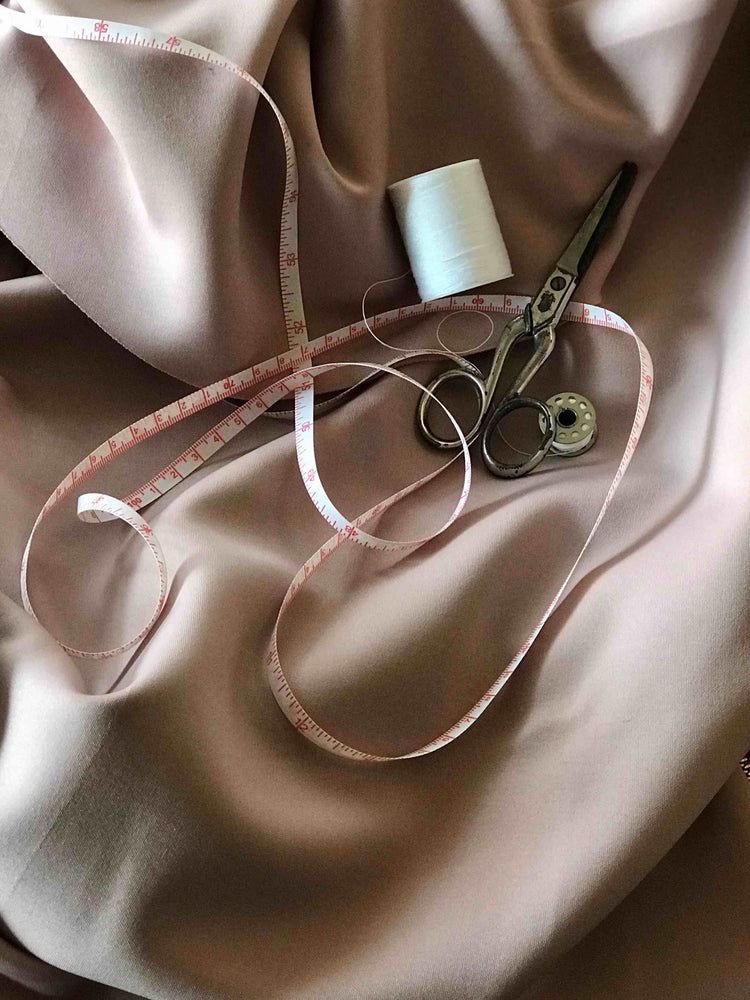 Close up image of pink solt silk with sewing tools